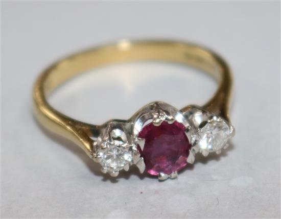 A modern 18ct gold and three stone ruby and diamond ring, size N.